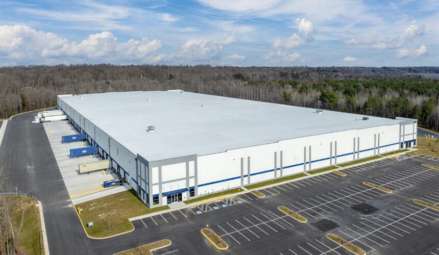 Exterior aerial view of a large industrial warehouse building with parking and loading docks.