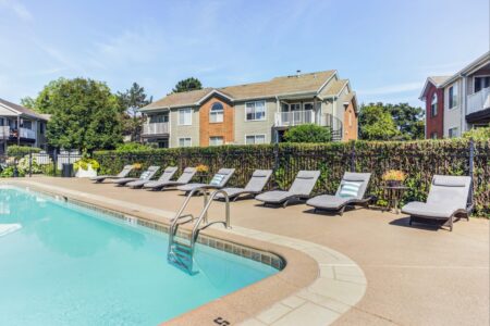 Swimming pool with lounge chairs and landscaped grounds at Ashford at Geneva, a multifamily apartment community in Geneva, Illinois.