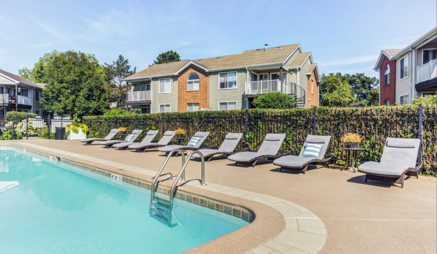 Swimming pool with lounge chairs and landscaped grounds at Ashford at Geneva, a multifamily apartment community in Geneva, Illinois.